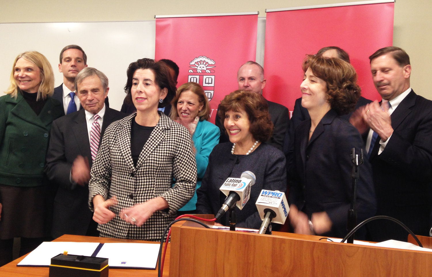 Gov. Gina Raimondo signs an executive order placing a voluntary cap of the annual growth of health care spending at 3.2 percent.