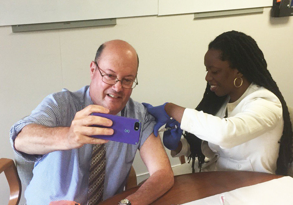With Dr. Nicole Alexander-Scott delivering a flu shot, Steve Klamkin of WPRO pulls off the extremely rare vaccination selfie, as part of the the R.I. Department of Health’s annual flu vaccine kickoff in 2017.