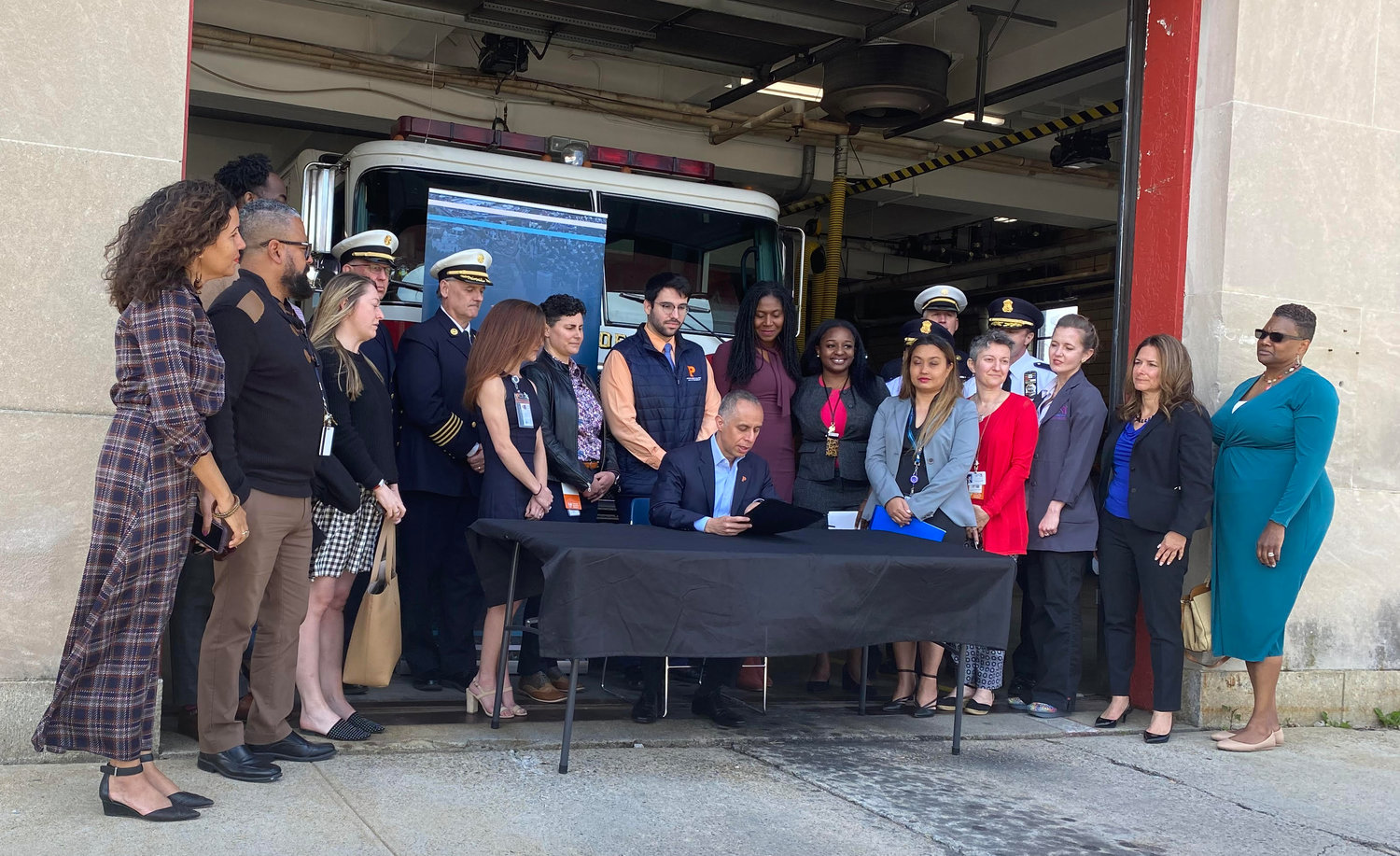 Mayor Jorge Elorza signs a proclamation in honor of Mental Health Awareness Month at the fire station on Branch Avenue, in a ceremony following the announcement of a new public safety initiative to embed behavioral health clinicians from The Providence Center at 9-1-1 offices and as part of a mobile response team.