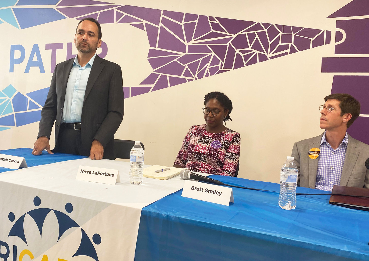 Gonzalo Cuervo, left, responds to questions at the Aug. 4 mayoral forum at the Jim Gillen Teen Center in Providence, as candidates Nirva LaFortune [center] and Brett Smiley [right] listen.
