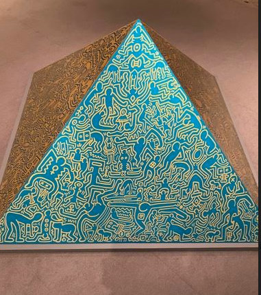 An anodized aluminum pyramid by Keith Haring, 1989, a gift of Rich Mancuso.